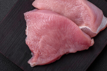 Raw turkey meat in the form of slices with salt, spices and herbs