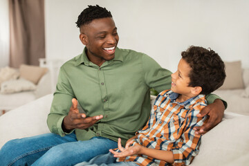 Happy Black Father and Little Son Sharing Stories Talking Indoor