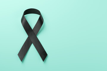 Black awareness ribbon on blue background. Mourning and melanoma symbol.