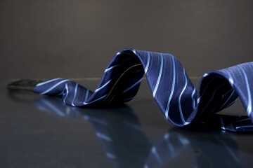 Stylish striped blue necktie resting on a countertop in a zig zag pattern