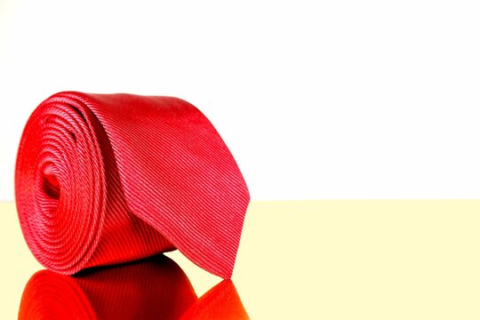 Closeup shot of a red fashion necktie rolled over white background