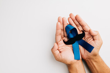 In November, men's health and Prostate cancer awareness take center stage. Man's hands embrace a...