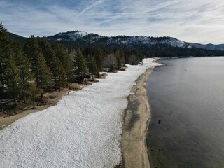 Aerial view of the beautiful Lake Tahoe near a snowy forest