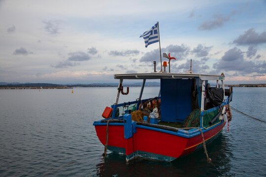 a boat anchored in a calm body of water with a flag