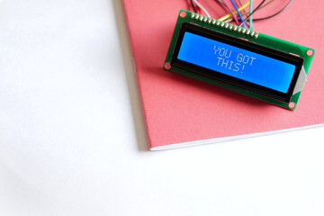 A glowing blue LCD Display shows the positive affirmation 'You Got This'. The display is placed on...