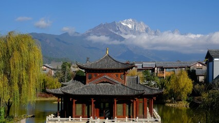 Fototapeta premium a building and some buildings with snow capped mountains in the background