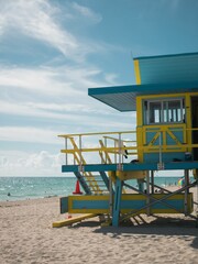 Vibrant lifeguard tower on a beach with pristine white sand stretching out to a calm blue ocean