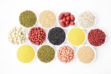 Obraz na płótnie Canvas Variety of raw cereals of different colors and types in small bowls against a white background