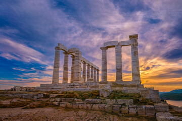 Sunset sky and ancient ruins of temple of Poseidon, Sounion, Greece