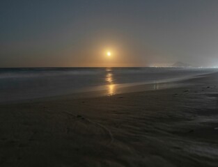 Spectacular views of the sea at sunset and the moon reflecting on the beach of Gandia. Spain.