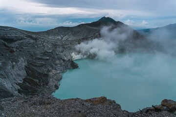 Aerial view of a blue acid lake with sulfur steam near Mount Ijen, Java, Indonesia