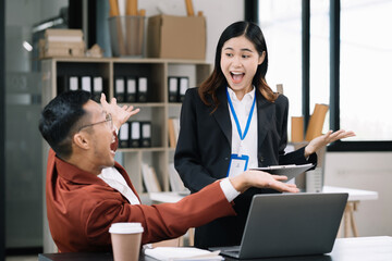 Successful business team, excited business people Keeping up arms and showing positive emotions, happy working in modern office on computer.
