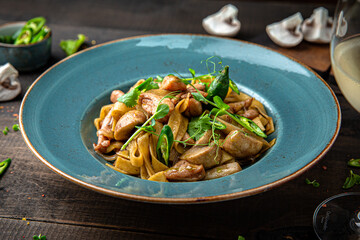 Pasta with chicken and mushrooms. Menu for a restaurant. Beautiful composition on wooden boards.
