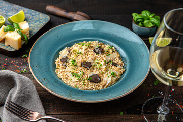Risotto with champagne, truffle and parmesan. Menu for a restaurant. Beautiful composition on wooden boards.