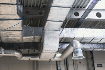Aluminum ventilation ducts, pipes suspended from the ceiling in a factory