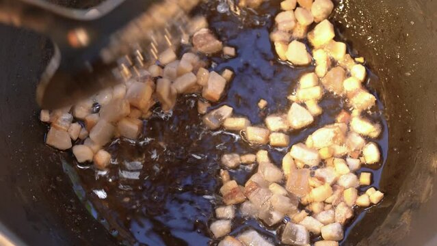 roasting of salted pork fatback on a red-hot pan, close-up	
