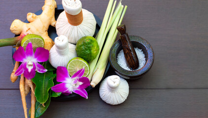Thai Spa treatment and Spa herbal compressing ball with candle on wooden background. Healthy Concept