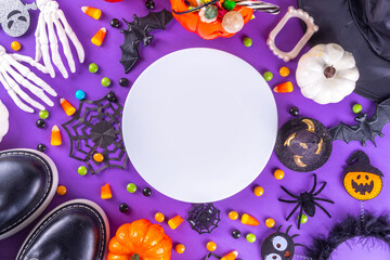 Obraz premium Bright colorful Halloween kids party accessories background, treat or trick holiday with colorful candies, traditional Halloween characters costumes, sweets, candy and decor top view copy space