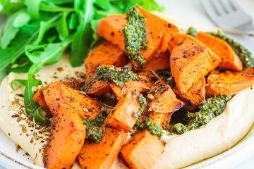 Vegan lunch - hummus, baked sweet potato and pesto, white background.