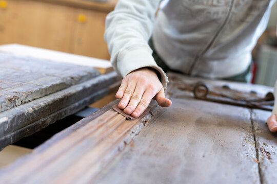 Artisan charpentier r&eacute;alisant des travaux de restauration sur une ancienne porte