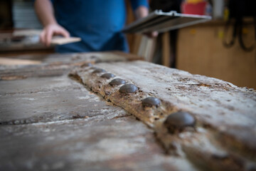 Artisan charpentier r&eacute;alisant des travaux de restauration sur une ancienne porte