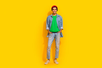 Obraz premium Full body photo of attractive young man hands pockets pants shopping posing wear trendy jeans clothes isolated on yellow color background