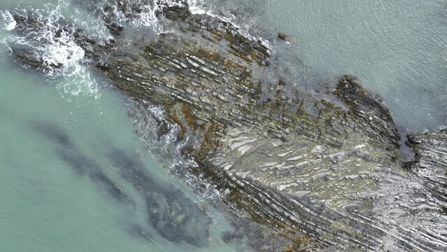 metamorphic rock formations on the shoreline in ireland