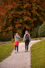 Fototapeta premium Mother and daughter are walking in autumn time. 