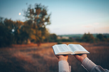 Bible in hands in nature, Christian concept