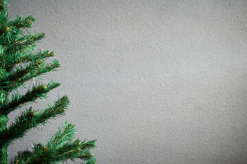 Christmas tree against a gray wall on left side