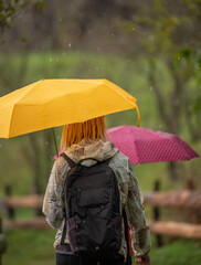 Mother and daughter walking in the rain on an early autumn day. 