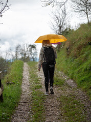 Mother and daughter walking in the rain on an early autumn day. 