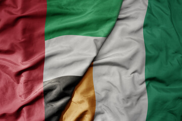 big waving realistic national colorful flag of united arab emirates and national flag of cote...