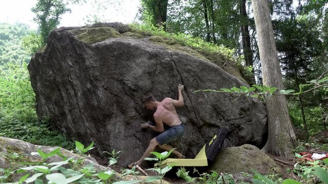 Sportler in der Natur, Erklimmt einen Felsen, Kraftvoll, Stille des Waldes