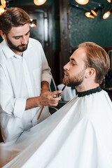 Using scissors. Man is visiting modern barber shop. Modern style