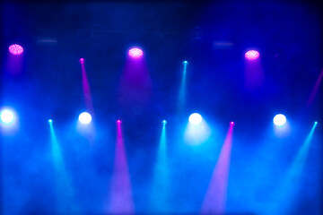Bright multi-colored iridescent lights of stage lighting. Background scene, performance. Concert...