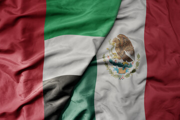 big waving realistic national colorful flag of united arab emirates and national flag of mexico .