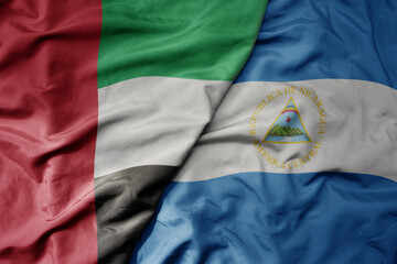 big waving realistic national colorful flag of united arab emirates and national flag of nicaragua .