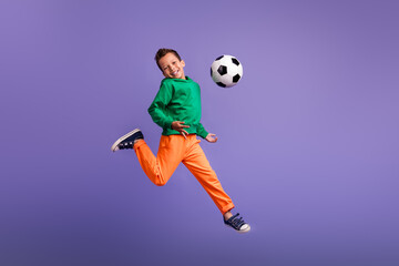 Fototapeta na wymiar Photo of positive optimistic boy team member running training football isolated on purple color background