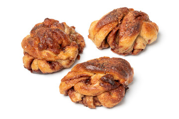 Three fresh homemade cinnamon rolls close up isolated on white background