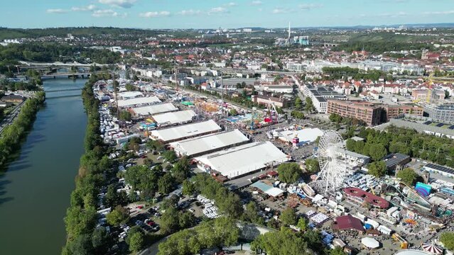 Eine Drohnenaufnahme die das Stuttgarter Volksfest zeigt, r&uuml;ckw&auml;rtsfliegend auch den Neckar zeigt.