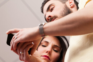 Viewed from below, couple absorbed in phones
