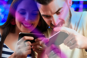 Couple competes in smartphone gaming, exuding excitement