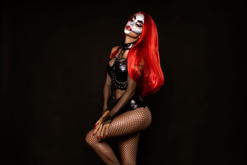 Sexy woman in a Halloween makeup and costume on black background. Halloween makeup and costume...