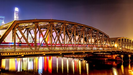 train is crossing a bridge illuminated by a night sky in China