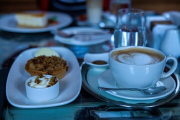 Clear glass table filled with a variety of delicious food and a cup of coffee