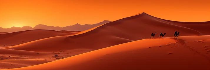  Saharan sand dunes, shades of red and orange, camel caravan in the distance, sun setting or rising © Marco Attano
