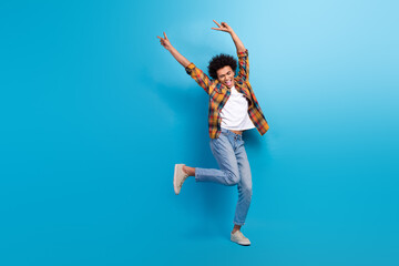 Full length photo of excited cool guy dressed checkered shirt dancing showing v-signs empty space...