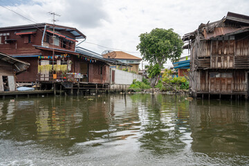 Obraz premium A klong or river channel of Chao Phraya river with residential buildings in Bangkok Thailand Asia