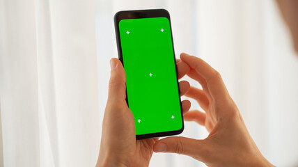 girl holding a phone with a green screen at home. Device. Smartphone. Social networks